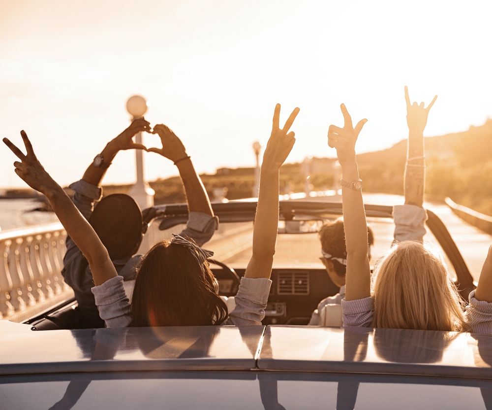 Friends on a summer car ride towards sunrise