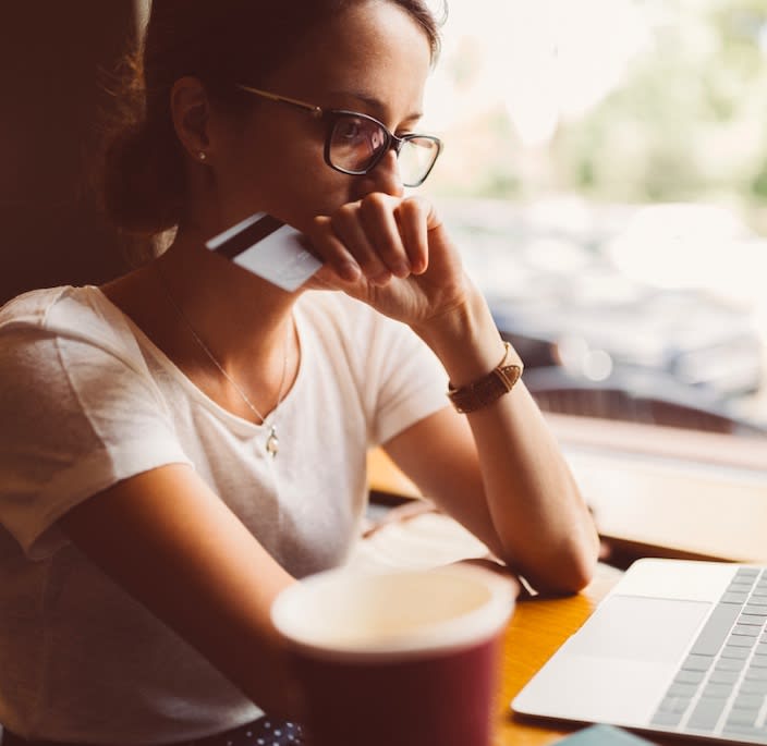 A student sitting in front of a laptop trying to pay a loan with a credit card