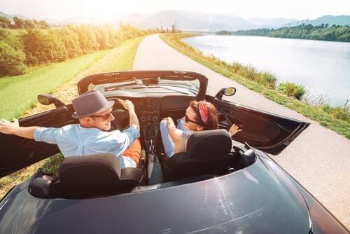 A couple going on a romantic ride on a loaned car