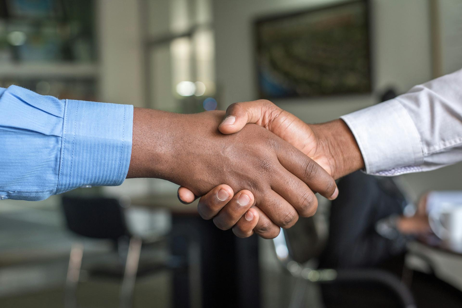 Two men's hands in a handshake (car loan transfer)