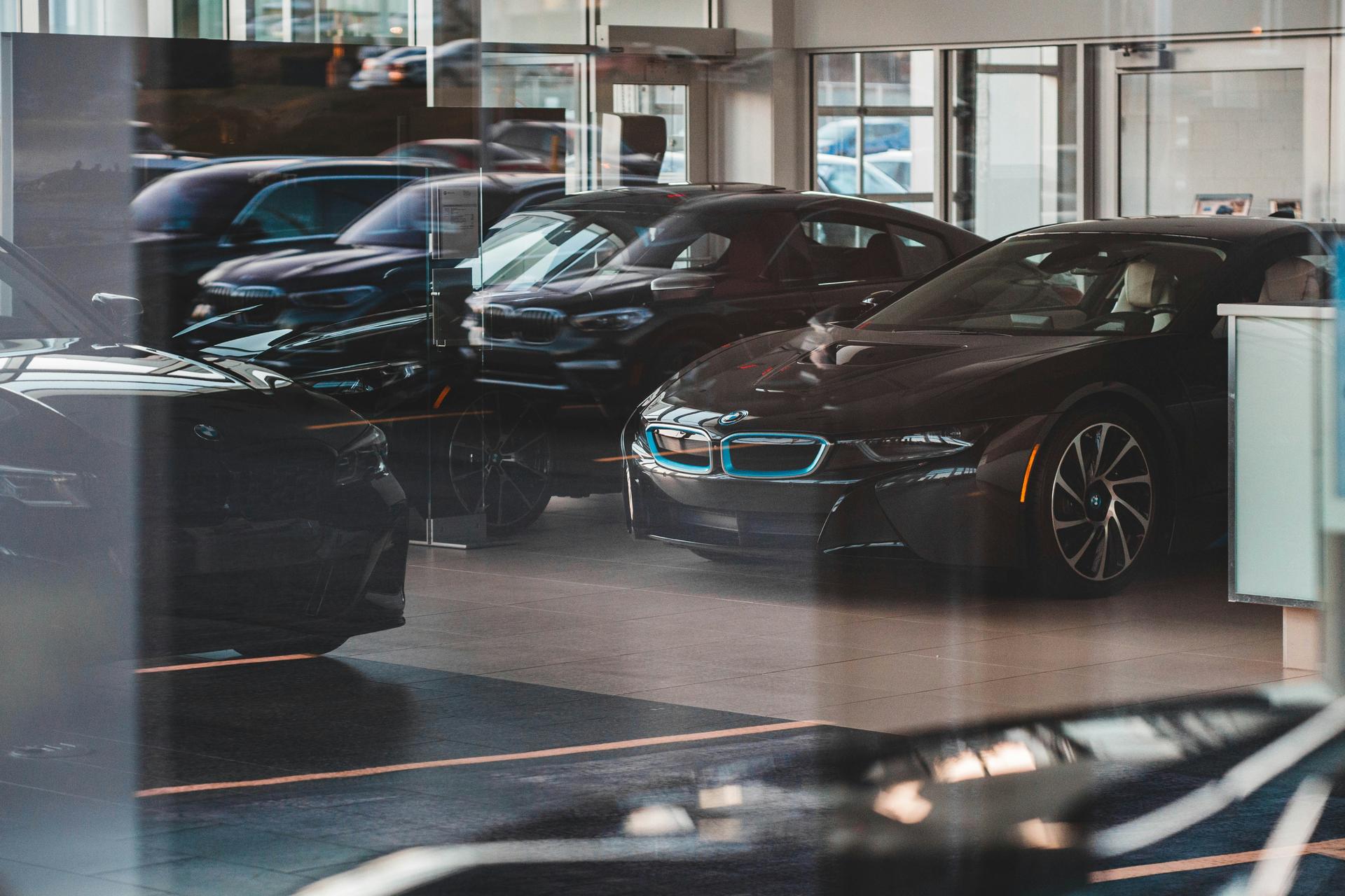 black BMWs in a dealership behind glass windows, dealership financing